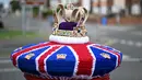 Sebuah foto yang diambil pada 2 Mei 2023 memperlihatkan mahkota rajutan yang dipajang di kotak pos di sebelahnya, menjelang penobatan Raja Charles III dan Permaisuri Camilla, di Rhyl, Wales utara. (Photo by Paul ELLIS / AFP)