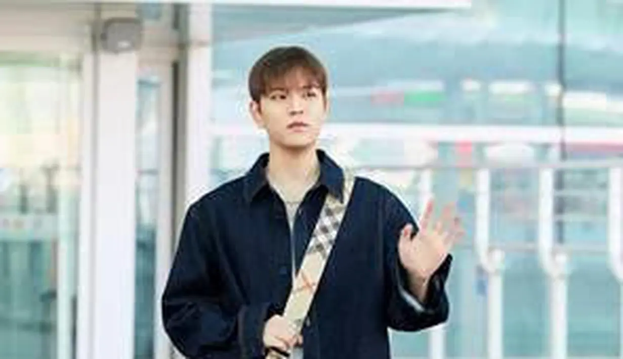 Ia kenakan kemeja denim dengan celana jins lurus yang digulung di bagian bawah berwarna Dark Indigo dan tas selempang Horseshoe berwarna hitam.