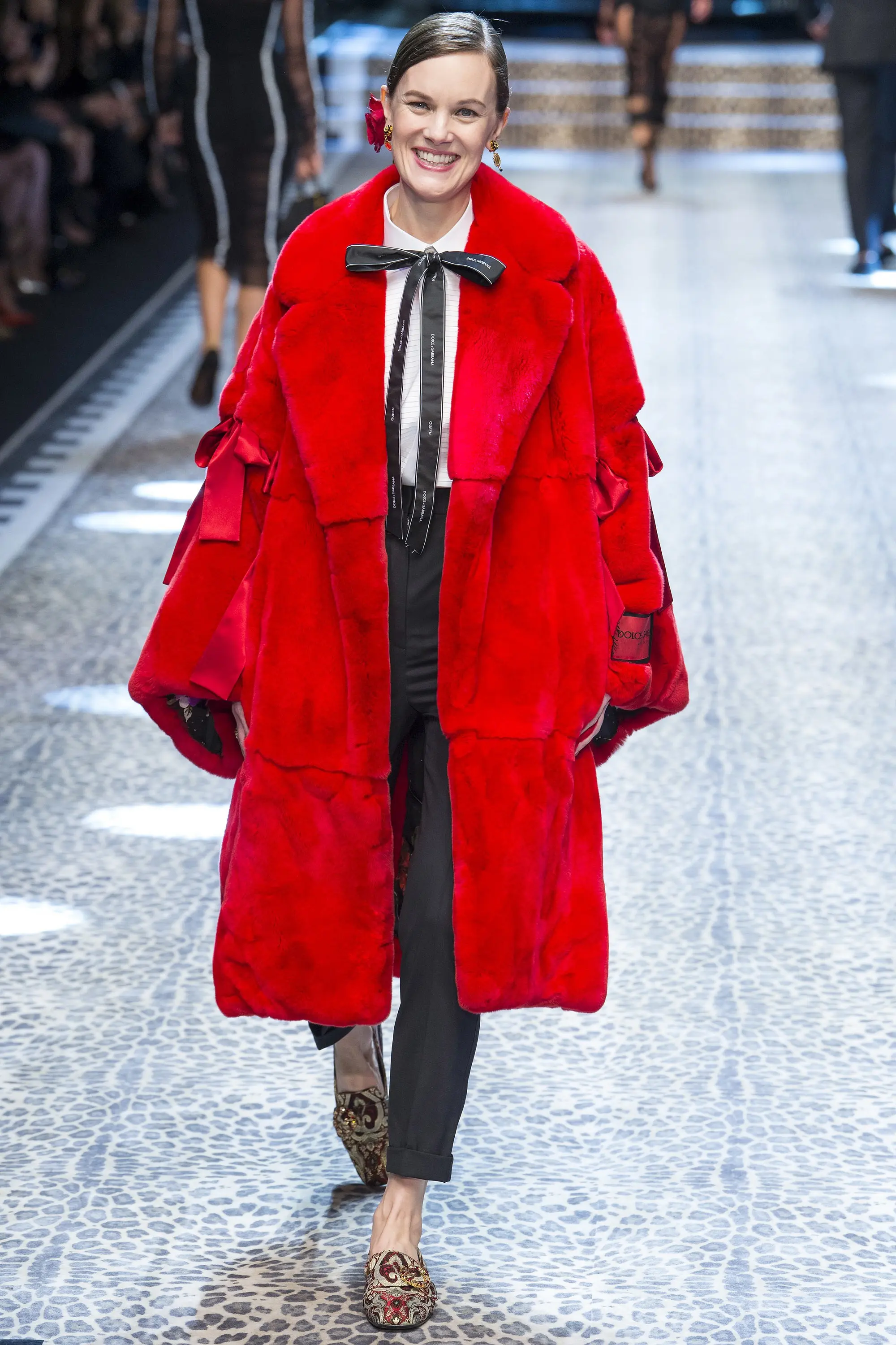 Long coat warna merah ini trendi banget rancangan Dolce & Gabbana . (Image: vogue.com)