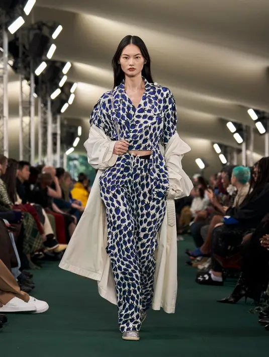 Seperti potret ini, model muncul dalam setelan busana motif buah stroberi warna biru yang dipadukan long coat putih. [Dok/Burberry]