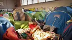 Seorang pria terbangun di gimnasium yang ditempati migran di lycee Jeanne-Bernard di Saint-Herblain, Nantes, Prancis (28/3). Sebuah keputusan pengadilan 28 Maret 2019, menyusul  permintaan  keuskupan, pemilik situs, untuk mengusir para migran yang menempati gymnasium.  (AFP Photo/Loic Venance)