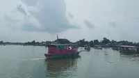 Sejumlah perahu yang membawa puluhan umat Buddha beserta  kota berisi ikan saat melaju ke tengah Danau Sipin Jambi, Selasa (26/5/2021). Puluhan umat Buddha di Jambi menggelar ritual Fangsheng dengan melepasliarkan ikan ke danau. (Liputan6.com/Gresi Plasmanto)