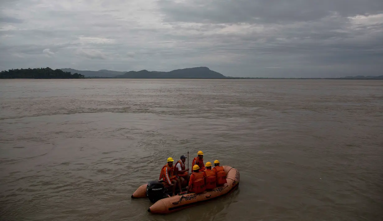Pasukan penanggulangan bencana berpatroli di sepanjang sungai Brahmaputra, kota Gauhati, India, Selasa (30/5). Beberapa negara bagian di India timur laut mengalami hujan deras sebagai efek topan Mora yang melanda selatan Bangladesh. (AP Photo/Anupam Nath)
