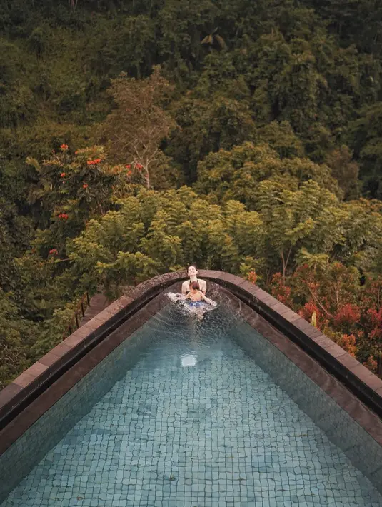 Suasana romantis nan asri terlihat dari foto ini. Di mana Sabai dan Bjorka terlihat sedang asik di kolam renang yang dikelilingi pemandangan pepohonan yang rimbun. (Instagram/ringgoagus)