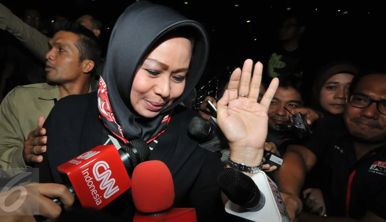 Istri Pelaksana Tugas (Plt) Gubernur Sumatera Utara Tengku Erry Nuradi, Evi Diana, menghindar dari wartawan usai diperiksa KPK, Jakarta, Kamis (5/11/15). Evi yang diperiksa sebagai saksi untuk Gatot Pujo Nugroho. (Liputan6.com/Helmi Afandi) 