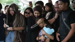 Jenazahnya dimakamkan pada hari yang sama di TPU Tanah Kusir, Jakarta Selatan. Tampak dalam foto, istri Gary Iskak, Richa Novisha (tengah) memeluk anaknya saat berada di dekat pusara sang suami di Taman Pemakaman Umum (TPU) Tanah Kusir, Jakarta Selatan, Sabtu (29/11/2025). (Kapanlagi.com/Budy Santoso)