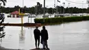 Warga melihat banjir yang meninggi dekat area komersial di pinggiran barat daya Camden, Sydney, Australia, Selasa (8/3/2022). (Muhammad FAROOQ/AFP)