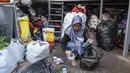 Seorang relawan bank sampah memilah sampah anorganik rumah tangga, baik berupa karton maupun botol plastik, Jakarta, Kamis 4 Juni 2026, sebagai bagian dari instruksi Pemprov DKI yang mewajibkan warga memilih dan memilah sampah untuk mengurangi beban sampah yang semakin menumpuk di ibu kota. (BAY ISMOYO/AFP)