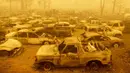 Lusinan kendaraan yang terbakar berada dalam asap tebal selama kebakaran Dixie di Greenville, California, Amerika Serikat, 6 Agustus 2021. Kebakaran besar yang melanda California utara menjadi yang terbesar ketiga dalam sejarah negara bagian itu. (JOSH EDELSON/AFP)
