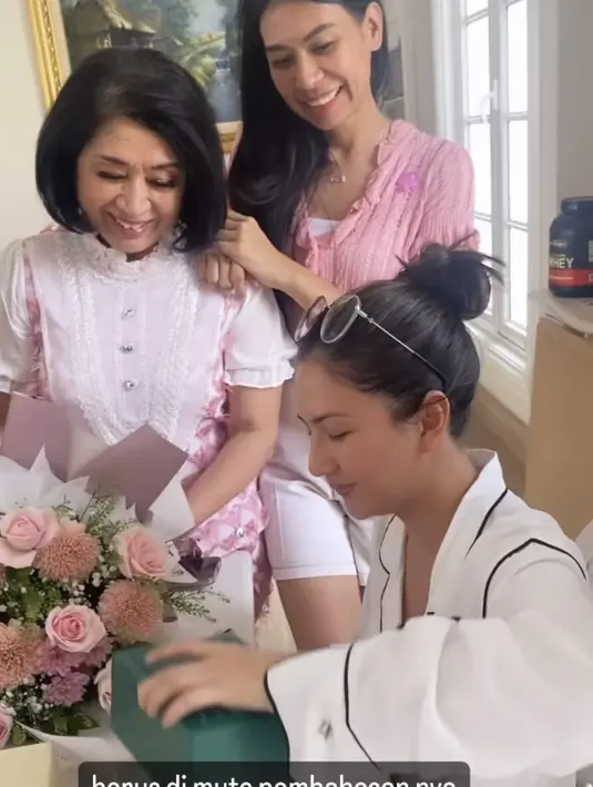 Dengan rambut hitam panjangnya yang diikat asal-asalan model bun saat membuka hadiah ulang tahun. [Instagram/@hannahaloho]