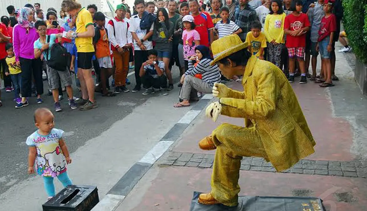 Anak kecil tampak menghampiri manusia patung di kawasan Sudirman saat Car Free Day (Liputan6.com/Miftahul Hayat)  