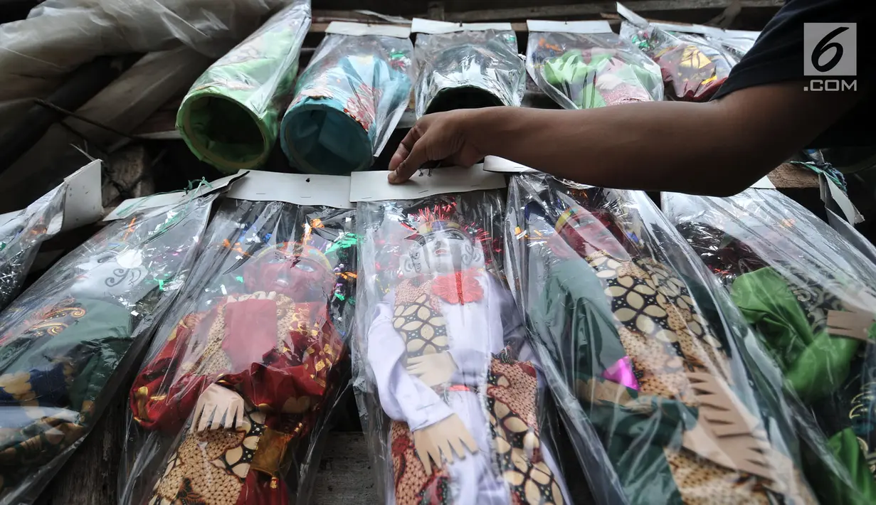 Andri saat menata miniatur ondel-ondel yang siap dijual di Jakarta, Selasa (19/3). Dalam sehari Andri mampu memproduksi sekitar 50-70 buah ondel-ondel yang dibanderol dengan harga Rp 30 ribu-Rp 50 ribu per buah. (merdeka.com/ Iqbal S. Nugroho)