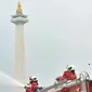 Petugas pemadam kebarakan menyemprotkan cairan disinfektan di kompleks Monumen Nasional (Monas), Jakarta, Senin (30/3/2020). Penyemprotan disinfektan ini dilakukan guna memutus rantai penyebaran virus Corona atau Covid-19 di pusat kota. (merdeka.com/Iqbal S. Nugroho)