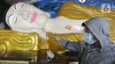 Petugas menyemprotkan cairan disinfektan ke patung Buddha tidur raksasa di Vihara Buddha Dharma dan 8 Posat, Bogor, Jawa Barat, Minggu (7/2/2021). Patung buddha tidur raksasa sepanjang 18 meter dan tinggi 5 meter tersebut dibersihkan setiap tahun menjelang Tahun Baru Imlek. (merdeka.com/Arie Basuki)