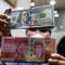 Sebelumnya, pada Selasa (5/5/2026), nilai tukar rupiah terhadap dolar AS bergerak melemah 11 poin atau 0,07 persen menjadi Rp17.405 per dolar AS. Tampak dalam foto, karyawan menunjukkan uang pecahan dolar Amerika Serikat (AS) dan rupiah di salah satu gerai penukaran mata uang asing, Jakarta, Rabu (5/5/2026). (Kapanlagi.com/Budy Santoso)