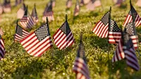 Aktivis dari COVID Memorial Project meletakkan ribuan bendera Amerika berukuran kecil di di halaman National Mall di Washington, Selasa (22/9/2020). Ribuan bendera itu menandai 200 ribu nyawa yang hilang akibat virus corona Covid-19 di Amerika Serikat. (AP Photo/J. Scott Applewhite)