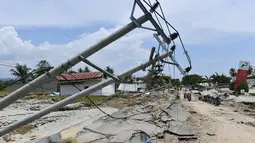 Tiang-tiang listrik roboh usai gempa dan tsunami melanda Kabupaten Sigi, Sulawesi Tengah, Kamis (4/10). Badan Nasional Penanggulangan Bencana (BNPB) mengatakan beberapa lokasi di Sigi terisolir akibat gempa dan tsunami. (ADEK BERRY/AFP)