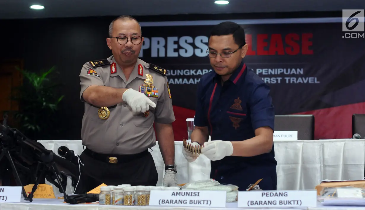 Kadiv Humas Polri Irjen Pol Setyo Wasisto (kiri) bersama Dirtipidum Bareskrim Polri Brigjen Herry Rudolf Nahak menunjukkan peluru aktif milik tersangka kasus penipuan calon jamaah umroh, Jakarta, Selasa (22/8). (Liputan6.com/Helmi Fithriansyah)