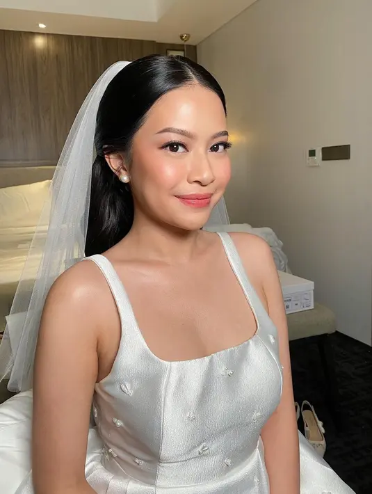 Gaun tersebut pun dipadukan Hanggini dengan short veil yang menjuntai di belakang. [@_bymao_/@luthfiaulia]