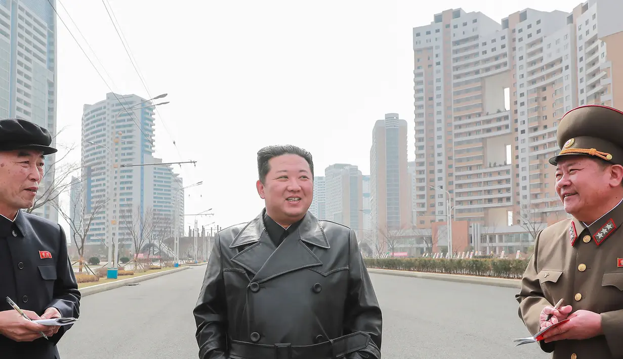 Pemimpin Korea Utara Kim Jong Un (tengah) berbincang dengan para pejabat saat memeriksa lokasi kompleks perumahan 10.000-flat yang sedang dibangun di Pyongyang (16/3/2022). Kim telah menghadiri upacara peletakan batu pertama situs tersebut Maret lalu. (AFP/STR/KCNA Via KNS)