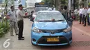 Petugas mengamankan mobil taksi yang hancur akibat dirusak oleh ojek online di Jakarta, Selasa (22/3). Akibat aksi saling serang antara taksi dan ojek online berimbas pada kerusuhan yang terjadi di beberapa titik di Jakarta. (Liputan6.com/Angga Yuniar)