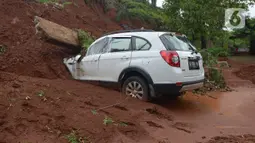 Mobil tertimpa longsoran dinding ruas jalan Tol JORR Cikunir, Bekasi, Jawa Barat, Kamis (2/1/2020). Hujan deras pada malam Tahun Baru 2020 membuat sejumlah titik jalan tol rawan longsor dan banjir. (merdeka.com/Imam Buhori)