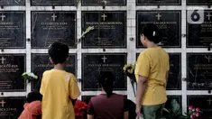 Keluarga berdoa saat berziarah ke salah satu makam bersusun atau kolumbarium di kompleks pemakaman Paroki Gereja St Servatius, Kampung Sawah, Bekasi, Jawa Barat, Kamis (26/12/2019). Kolumbarium setinggi dua meter tersebut dibangun oleh pengelola sejak awal 2018. (merdeka.com/Iqbal Nugroho)