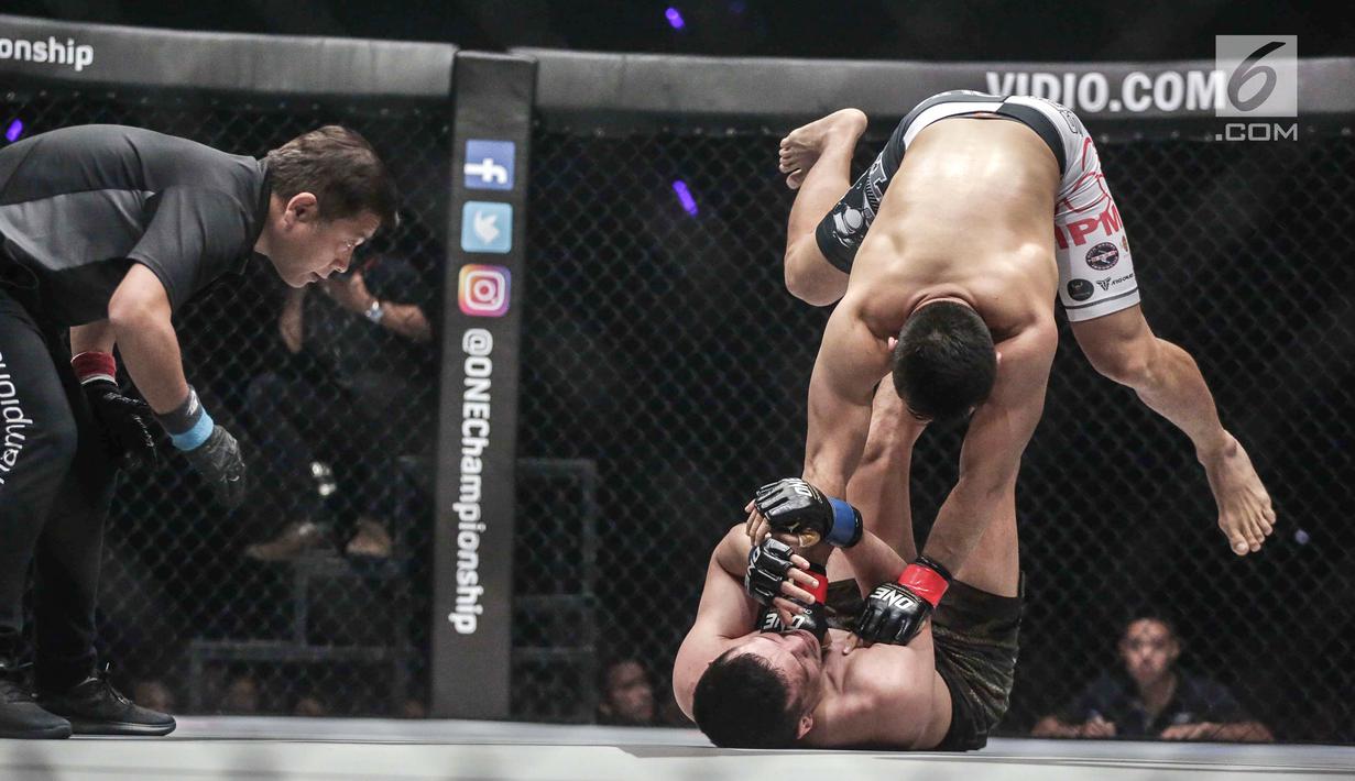 Dua petarung Indonesia Yohan Mulia Legowo (bawah) berusaha melakukan tendangan kepada Victorio Senduk (atas) pada laga One Championship di Jakarta, Sabtu (20/1). Pada laga tersebut Victorio Senduk menang atas Yohan Mulia. (Liputan6.com/Faizal Fanani)