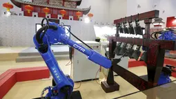 Dua robot CTR bermain lonceng kuno asli Cina pada Pameran Dunia Robot selama Konferensi Robot Dunia di Beijing, Cina,  (24/11). Konferensi robot ini diadakan selama tiga hari dari senin lalu. (REUTERS/Jason Lee)