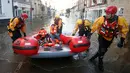 Tim regu penyelamat menyisir lokasi pemukiman warga yang terendam banjir menggunakan perahu karet di Tadcaster, Inggris utara, Minggu (27/12). Banjir akibat luapan sungai Ouse yang telah memperburuk sejumlah wilayah Inggris utara. (REUTERS/Andrew Yates)