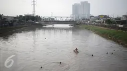 Sejumlah anak berenang di aliran kali besar Banjir Kanal Barat, Jakarta, Sabtu (11/3). Anak-anak ini mengaku nekat berenang karena tidak mampu mengakses fasilitas kolam renang ataupun sarana bermain lainnya. (Liputan6.com/Faizal Fanani)
