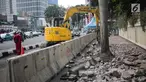 Pekerja dibantu alat berat merevitalisasi trotoar di kawasan Bundaran HI, Jakarta Pusat, Senin (15/7/2019). Penantaan ini dilakukan untuk mempercantik trotoar dan memberikan rasa nyaman bagi pejalan kaki. (Liputan6.com/Faizal Fanani)