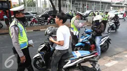Polisi berbincang dengan pengandara motor saat Operasi Zebra 2015 di kawasan Cempaka Putih, Jakarta, Senin (26/10/2015). Operasi Zebra 2015 berlangsung hingga 4 November 2015 bertujuan untuk menekan pelanggaran lalulintas. (Liputan6.Com/Angga Yuniar)