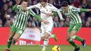 Luka Modric mencoba melewati hadangan pemain Real Betis pada laga lanjutan La Liga Spanyol yang berlangsung di stadion Benito Villamarin, Senin (14/1). Real Madrid menang 2-1 atas Real Betis. (AFP/Cristina Quicler)