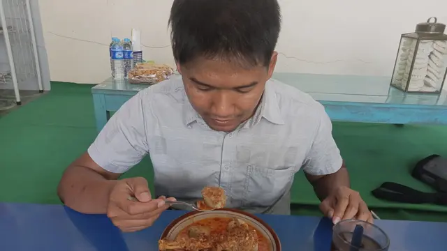 Pengunjung dari Sleman, Yogyakarta, Idris Luthfi ketika menyantap kuliner Lontong Mbleyer. (Liputan6.com/Ahmad Adirin)