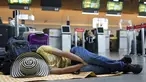 Seorang penumpang maskapai Viva Air tidur di bandara setelah maskapai berbiaya rendah itu menangguhkan operasinya di Bandara Internasional El Dorado di Bogota, Kolombia, Selasa (28/2/2023). Maskapai sedang menunggu penyelesaian proses integrasi dengan sekelompok maskapai penerbangan yang harus disetujui oleh otoritas Kolombia. (AP Photo/Fernando Vergara)