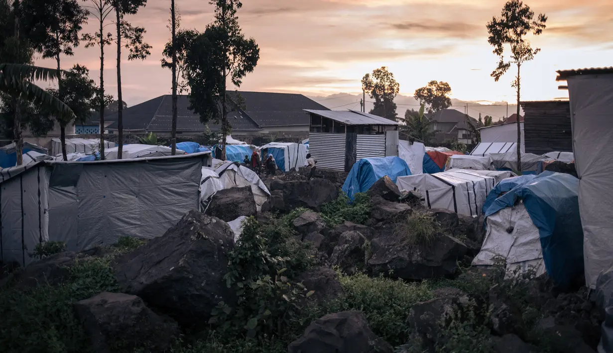 Kondisi mereka - berdesakan di gubuk-gubuk darurat - jauh lebih suram dibandingkan dengan pemandangan matahari terbenam yang memukau di belakang mereka. (ALEXIS HUGUET / AFP)