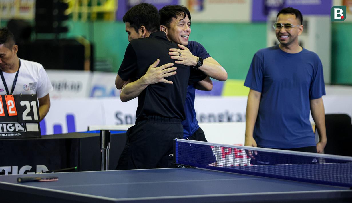 Ariel Noah dan Desta saling berpelukan setelah berakhirnya laga dadakan tunggal putra Turnamen Olahraga Selebriti Indonesia (TOSI) season 2 di GOR POPKI Cibubur, Jakarta Timur, Sabtu (13/01/2024). Ariel Noah kalah 0-2 (18-21, 19-21). (Bola.com/Bagaskara Lazuardi)