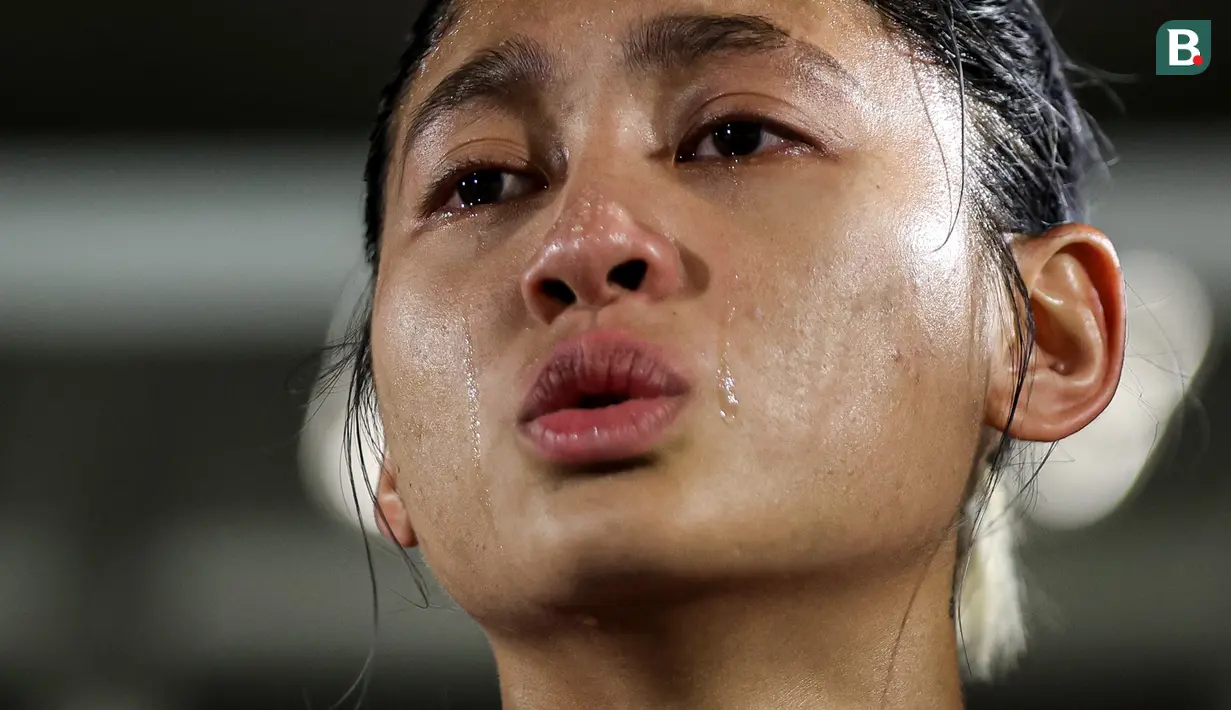 Pemain Timnas Indonesia Putri, Zahra Muzdalifah tak mampu menahan air mata saat menyanyikan lagu kebangsaan Indonesia Raya sebelum laga persahabatan melawan Singapura di Stadion Madya, Senayan Jakarta, Selasa (28/05/2024). (Bola.com/Bagaskara Lazuardi)