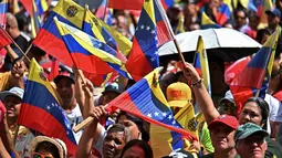 Para pendukung Nicolas Maduro berkumpul di beberapa titik di Caracas untuk memprotes intervensi militer Amerika Serikat. Tampak dalam foto, pendukung mantan Presiden Venezuela, Nicolas Maduro, saat menggelar aksi unjuk rasa di Caracas pada Minggu 4 Januari 2026. (Juan BARRETO/AFP)