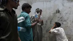 Sejumlah orang saat menunggu giliran untuk mengambil air saat cuaca panas yang ekstrem di Karachi, Pakistan, (23/6/2015). Gelombang panas yang telah menewaskan lebih dari 400 jiwa di kota selatan Pakistan. (REUTERS/Akhtar Soomro)