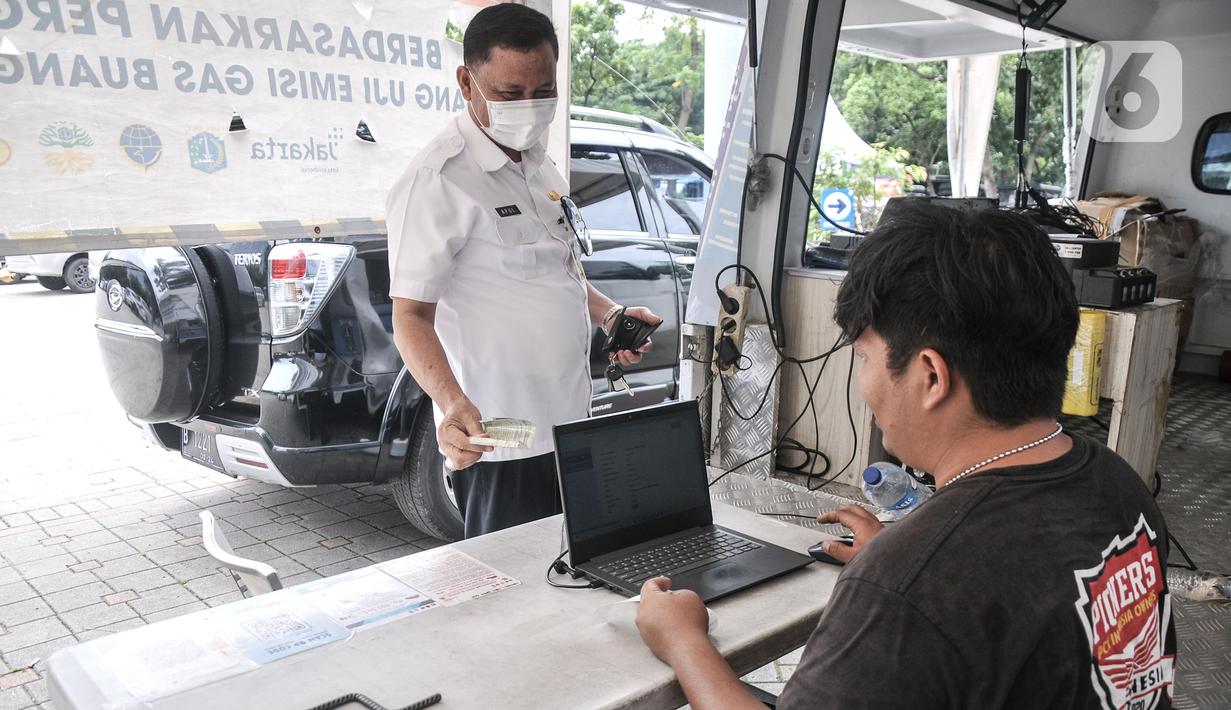 Petugas melayani pengunjung yang menjalani uji emisi mobilnya di IRTI Monas, Jakarta, Rabu (15/2/2023). Mobil yang telah lolos uji emisi akan dikenakan tarif parkir sebesar Rp 4.000 per jam, sedangkan yang belum lolos dikenakan tarif sebesar Rp 7.500. (merdeka.com/Iqbal S. Nugroho)