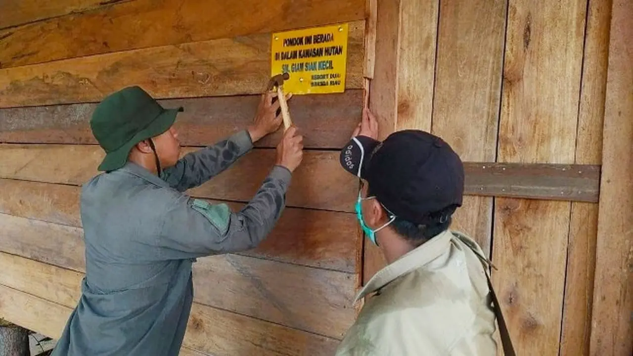 Petugas memasang tanda di pondok diduga milik perambah hutan Suaka Margasatwa Giam Siak Kecil.