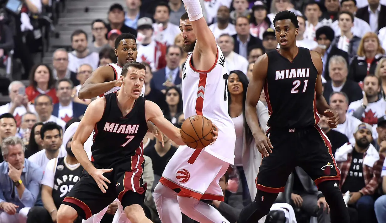 Miami Heat guard Goran Dragic (7) menggiring bola melewati hadangan Toronto Raptors center Jonas Valanciunas (17) pada NBA Playoffs di Air Canada Centre, Toronto, Selasa (3/5/2016). (Reuters/Mandatory/Dan Hamilton-USA TODAY Sports)