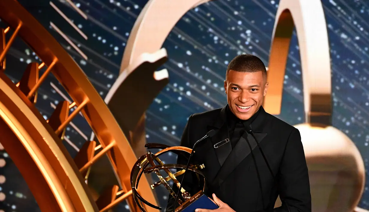 Striker PSG, Kylian Mbappe, menerima trofi pemain terbaik Liga Prancis di Paris, Minggu (19/5). Mbappe dinobatkan jadi pemain terbaik Liga Prancis. (AFP/Franck Fife)