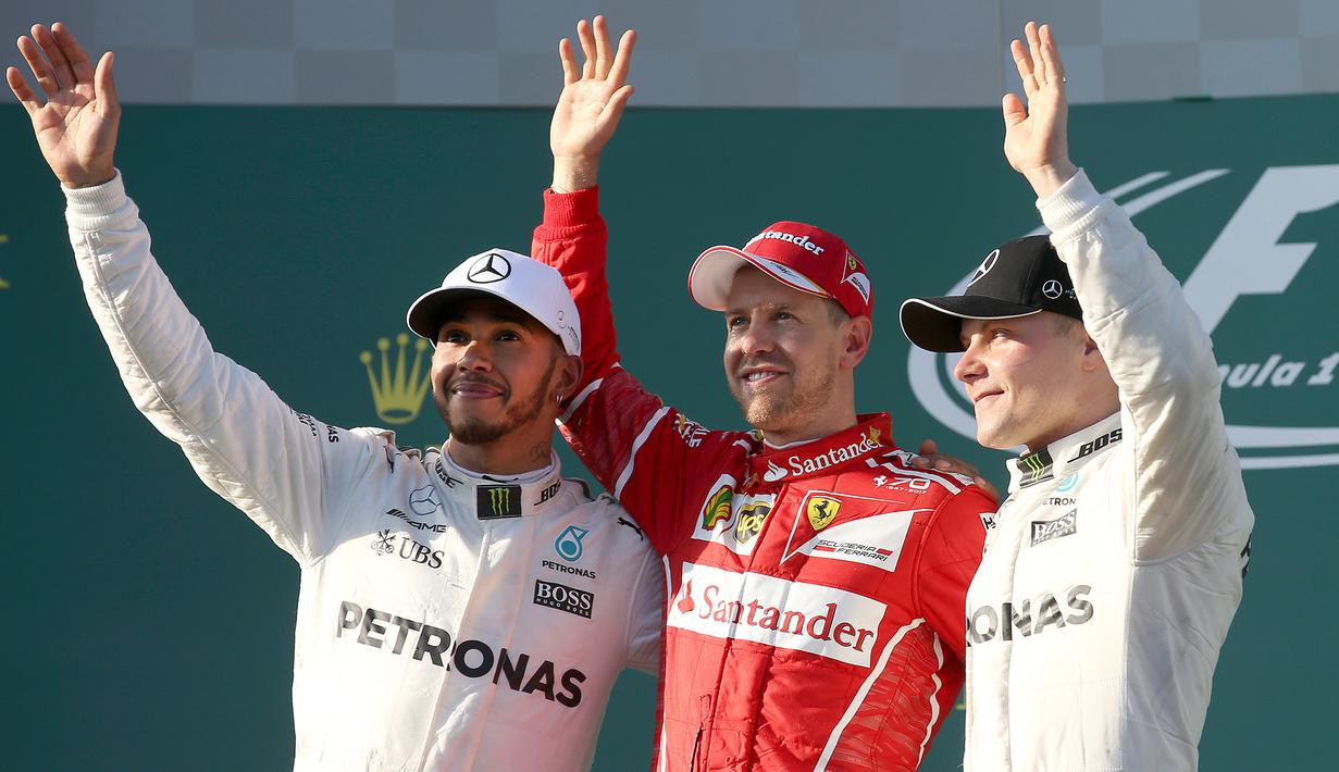 Pembalap Mercedes, Lewis Hamilton, pembalap Ferrari, Sebastian Vettel dan pembalap Mercedes, Valtteri Bottas melambaikan tangan ke arah penggemar di atas podium balapan GP Australia di Sirkuit Albert Park, Melbourne, Minggu (26/3). (AP Photo/Rick Rycroft)