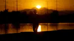 Seorang pelari jogging di sepanjang Danau Kota Tempe saat matahari terbit, Rabu, 12 Juli 2023 di Tempe, Arizona. Jutaan orang di seluruh Barat Daya mengalami gelombang panas bersejarah. (AP Photo/Matt York)