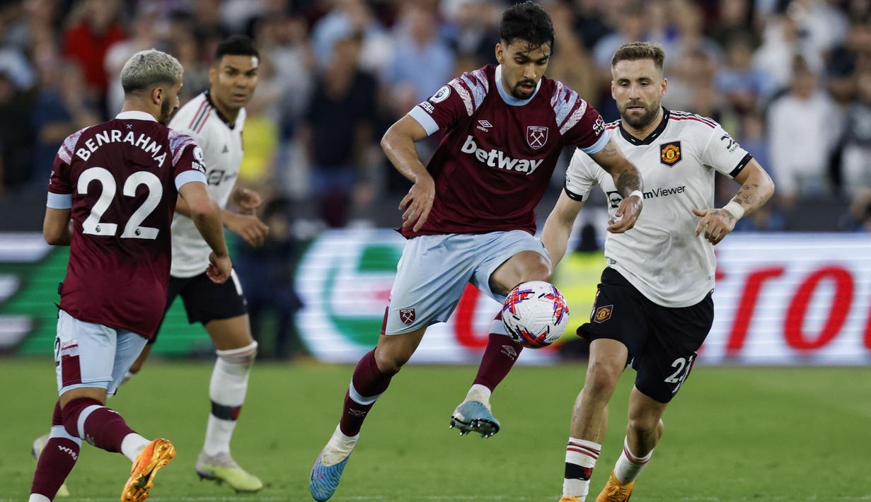 Pemain West Ham United, Lucas Paqueta, mengontrol bola dibayangi pemain MU dalam laga pekan ke-35 Premier League 2022/2023 yang berlangsung di London Stadium, Senin (8/5/2023) dini hari. (AFP/Ian Kington)