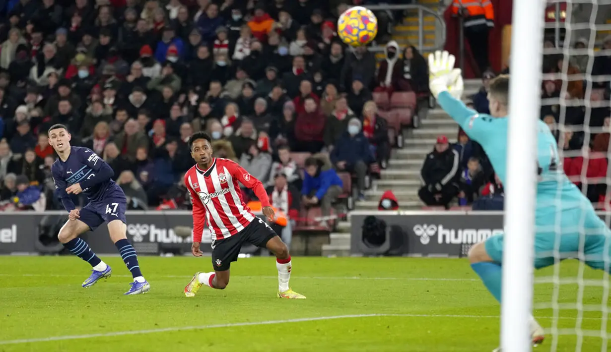 Penjaga gawang Southampton Fraser Forster menghentikan tendangan dari pemain Manchester City Phil Foden (kiri) pada pertandingan sepak bola Liga Inggris di Stadion St Mary, Southampton, Inggris, 22 Januari 2022. Manchester City bermain imbang 1-1. (AP Photo/Kirsty Wigglesworth)