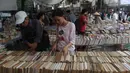 Seorang wanita mencari buku yang di dijual selama pameran buku bekas di Hanoi, Vietnam (26/10).( AFP Photo/Hoang Dinh Nam)